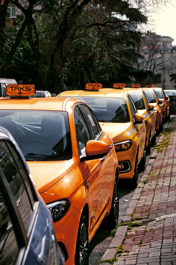 who-we-are Close-up of multiple yellow taxis on a cobblestone street, hinting at lively urban transportation.