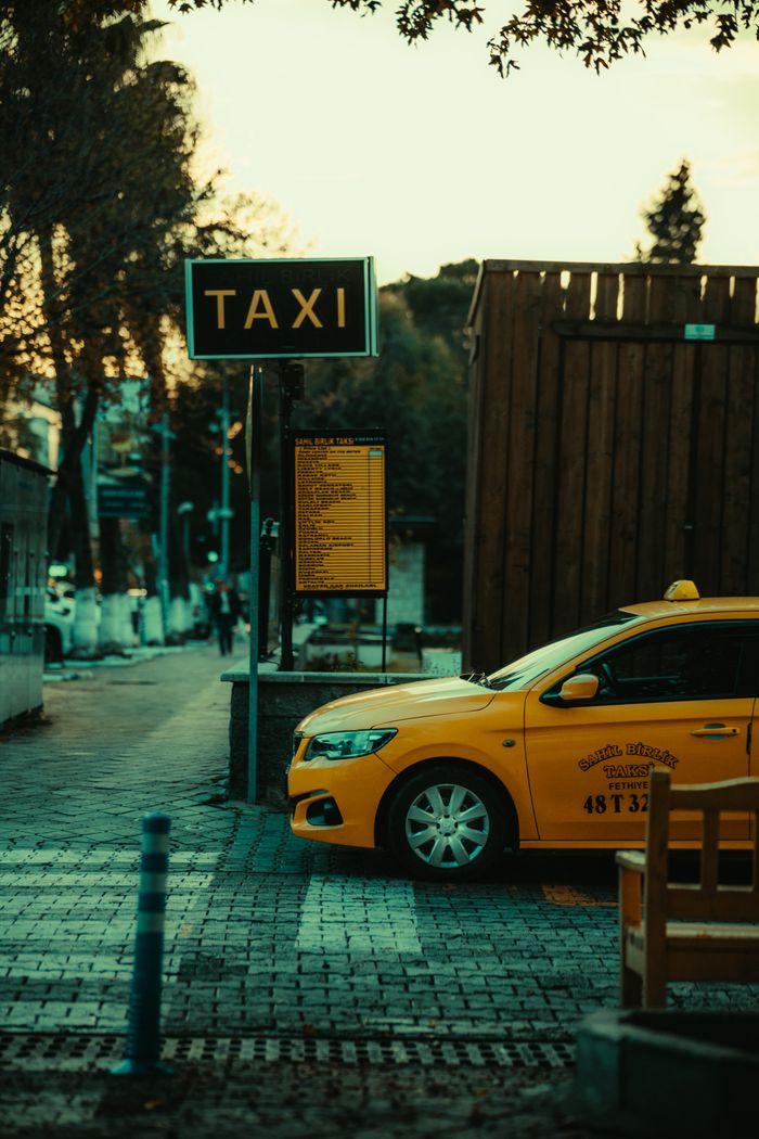 journey Yellow taxi parked at a city taxi stand during sunset, offering an urban street view.